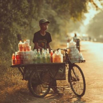 暑期的8月早上的三界鎮街頭吃包子,一輛賣西瓜的三輪車停在馬路邊,老伯正在稱西瓜。